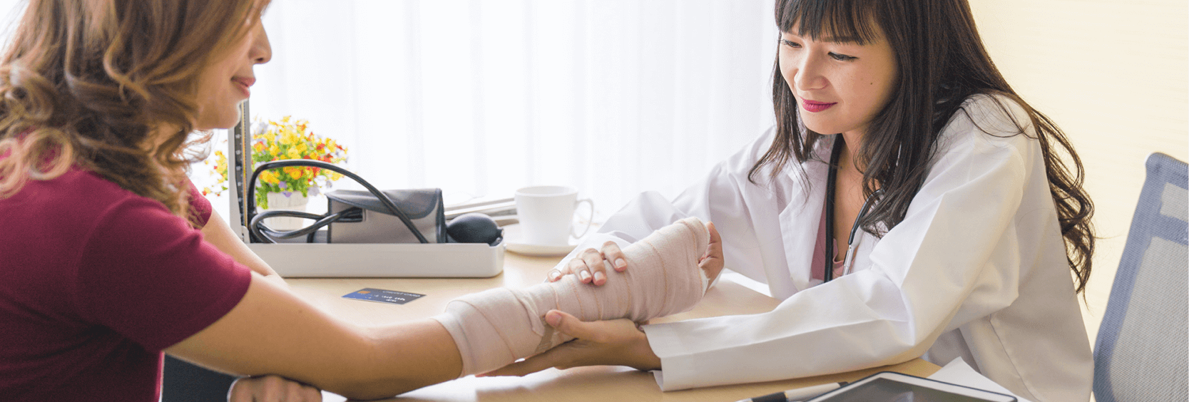 1200x406_Disability Doctor looking at patient's arm in cast