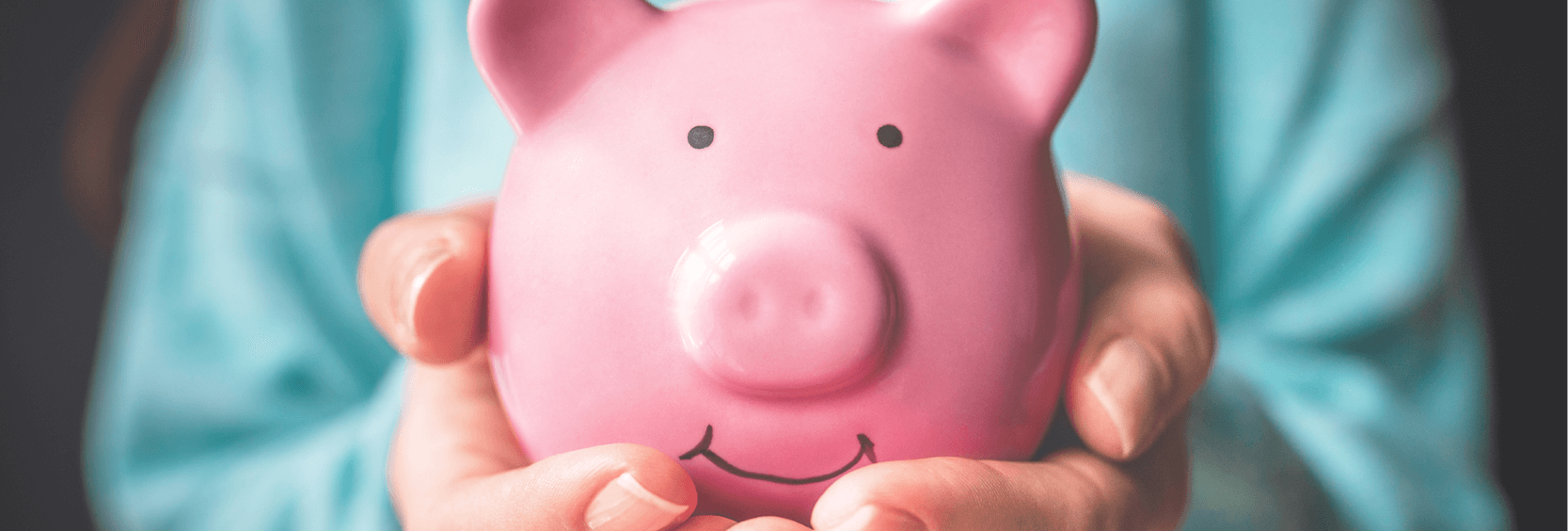 Person holding a pink piggy bank