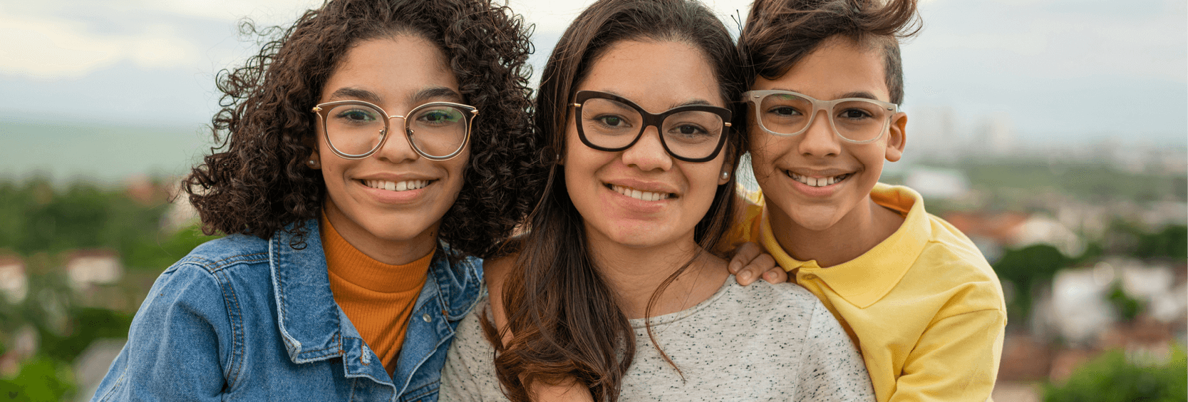 1200x406_Vision sisters Closeup of sisters and brother wearing glasses and osing outside